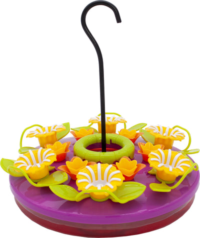 A purple hummingbird feeder with yellow and orange flower-shaped ports, green leaves, and a black hanging hook.