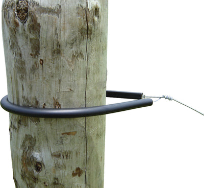 Close-up of a black Patriot Wrap Around Insulator secured around a weathered wooden post with a wire attached.