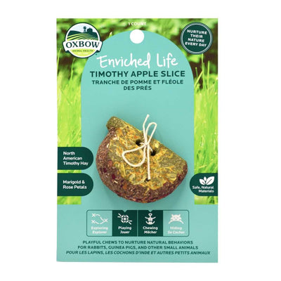 Packaged Oxbow Enriched Life Timothy Apple Slice with a string-tied treat on a blue card against green grass background.