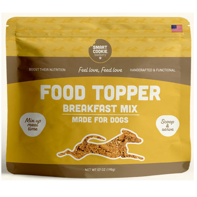 Front view of a yellow and brown packaged product labeled 'Smart Cookie Barkery Food Topper Breakfast Mix Made for Dogs' with a net weight of 7 oz.