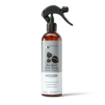 Front view of a Kin & Kind Patchouli Pet Smell Coat Spray bottle with a spray nozzle, amber liquid, and gray label.