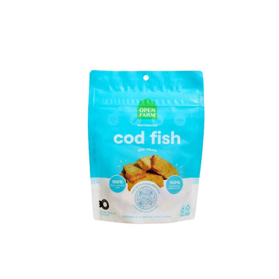 Front view of a blue and white packaged Open Farm dog treat bag labeled 'cod fish' with a stack of dehydrated treats.
