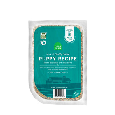 Front view of Open Farm dog food pouch labeled 'Puppy Recipe' with teal packaging and visible contents.
