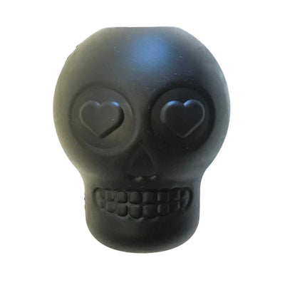 Close-up of a black skull-shaped treat dispenser with heart-shaped eyes and detailed teeth.