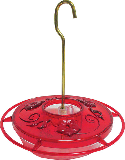 Red plastic hummingbird feeder with floral design and brass hook, front view close-up