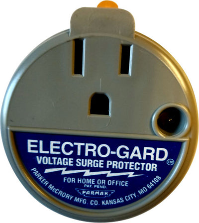 Close-up of a gray and blue Electro-Gard voltage surge protector with a circular design and visible outlets.
