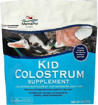 Front view of a packaged MannaPro Kid Colostrum Supplement in blue and white packaging, showing a goat kid being bottle-fed.