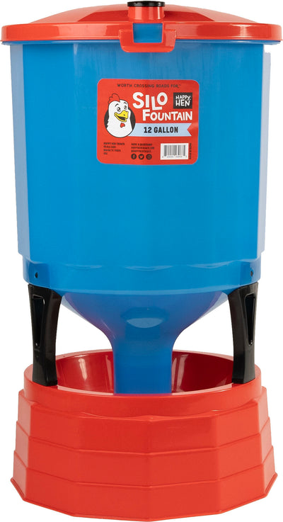 A blue and red plastic Happy Hen Silo Fountain 12-gallon water container with a red base and black supports.