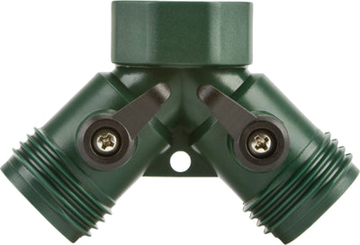 Close-up of a green plastic hose connector with two threaded ends and shut-off valves.